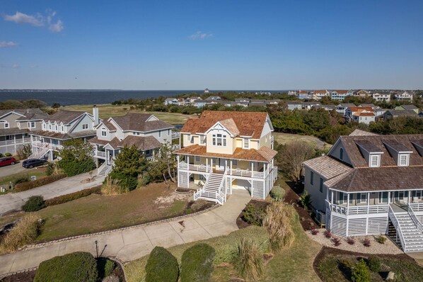 A coastal residential area with houses featuring prominent porches and a large central house with a prominent porch and staircase.