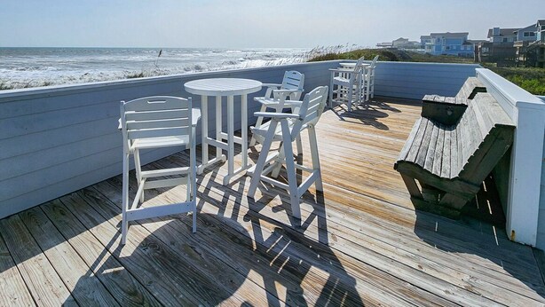 A wooden deck with white outdoor furniture overlooking the ocean. - Our Legacy - Dog Friendly Oceanside 4 BR Cottage with Community Pool access (Duck)