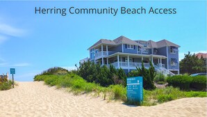 A beach with a sign indicating Herring Community Beach Access.