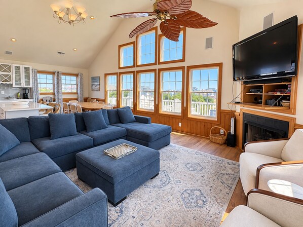 A spacious living area with a sectional sofa, a flat-screen TV, and a fireplace.