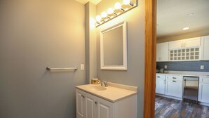 A bathroom with a vanity, mirror, and lights.