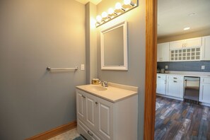 A bathroom with a vanity, mirror, and lights.