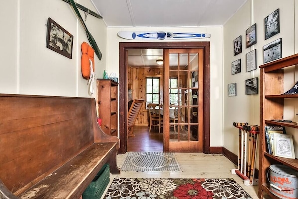 A wooden bench, a surfboard, and a bookshelf with various items.
