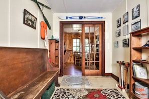 A wooden bench, a surfboard, and a bookshelf with various items.