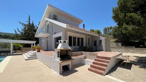 A modern house with a patio, outdoor seating, and a pool. - villa aphrodite (Maritsa)