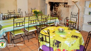 A dining room with a long table, chairs, a clock, and a fireplace. - Spacious Historic Presbytery, Sleeps 15, Garden, WiFi, Near Châteaux & La Roche-Posay (Bossay-sur-Claise)