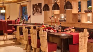 A restaurant with wooden chairs, a red tablecloth, and a variety of food and drinks. - Holiday Apartment "Alpenhof Lodge Ifinger" with Mountain View, Breakfast, Wellness & Wi-Fi (Saltaus)
