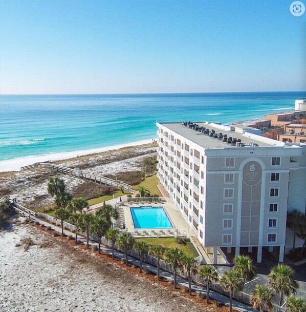 Een hotel met zwembad, uitzicht op het strand en toegang tot het strand.