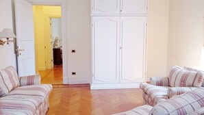 A room with two sofas, a wardrobe, and a wooden floor. - Roman Holidays Boutique (Rome)