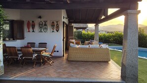 A patio area with stone flooring, outdoor furniture, and a view of the sea. - Villa Janas with private pool🏖️ (Budoni sardegna)