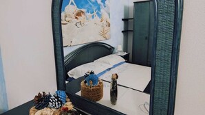 A bedroom with a large mirror, a bed with white bedding, and decorative items on the nightstand. - Villa Janas with private pool🏖️ (Budoni sardegna)