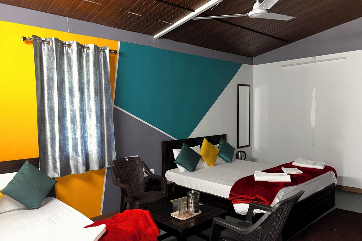 Une chambre d’hôtel équipée d’un lit, d’un bureau, d’une chaise, d’une machine à café et d’une fenêtre avec des rideaux.