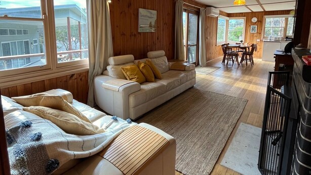 Una sala acogedora con sofá, mesa de comedor y zona de cocina.