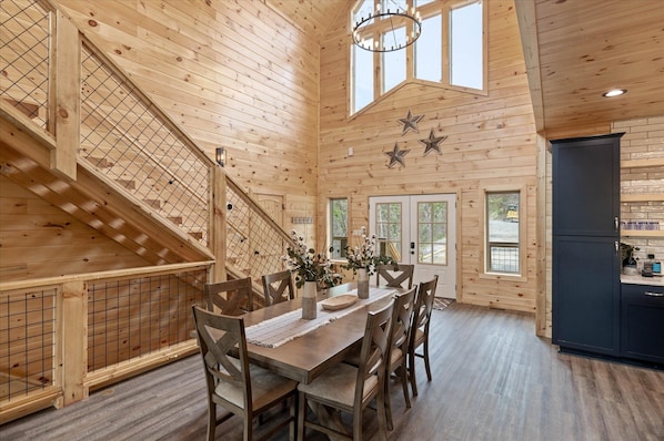 Stunning interior with a high ceiling, staircase, and dining area.
