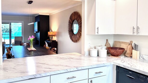 A modern kitchen with white cabinets, a marble countertop, and a Bosch dishwasher. - Spacious 3-Level Townhouse w/ 3 Community Pools, Tennis & Parking Pass for Rehoboth Beach (Rehoboth Beach)