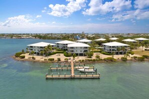A waterfront property with multiple white buildings, a dock, and a clear view of the water. - Changes in Latitude (MARATHON)