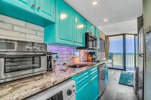 Enjoy cooking in this kitchen with an oven and stainless steel range, offering a view of the outdoors.