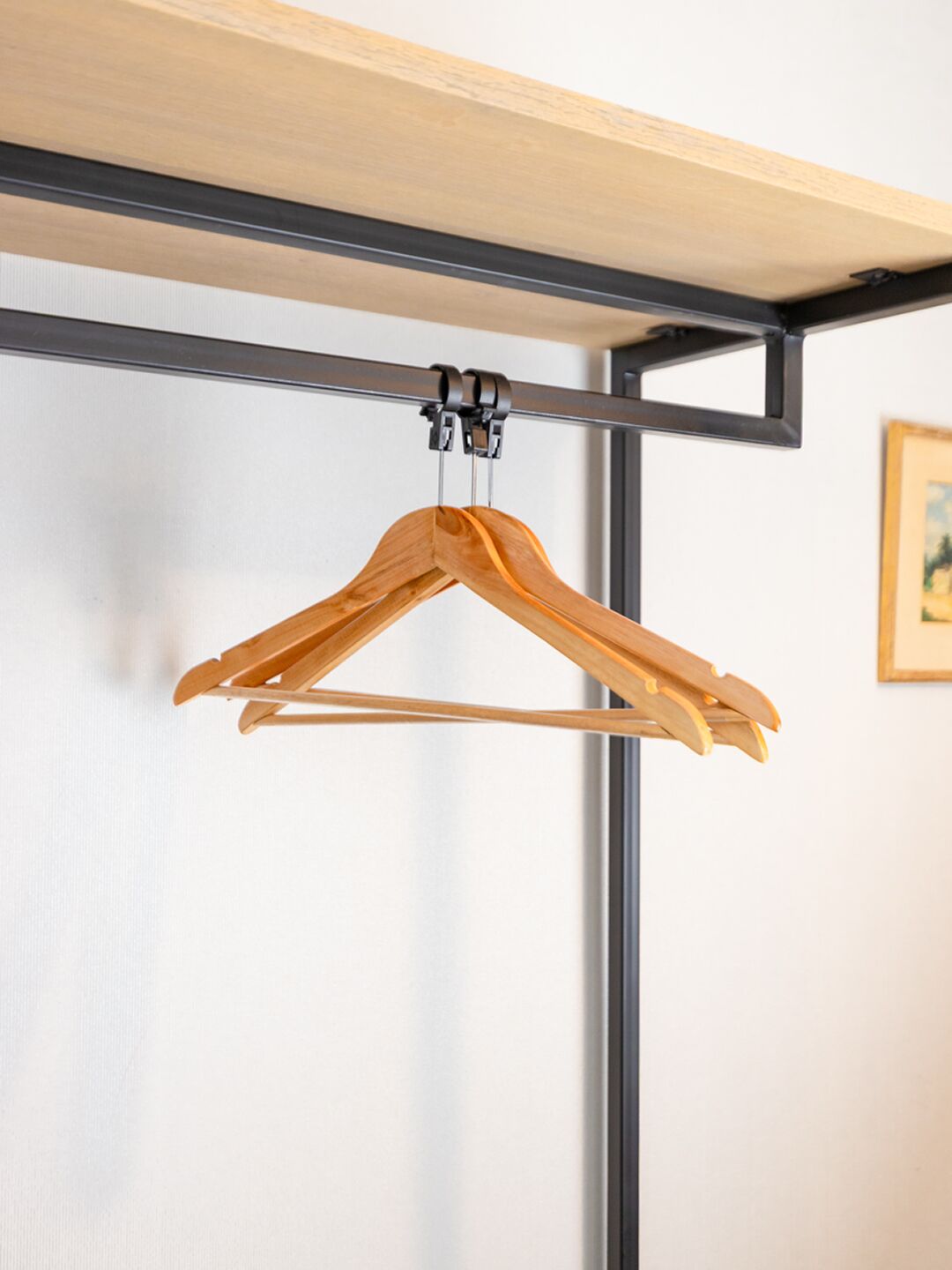 A wooden hanger suspended from a metal frame.