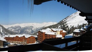 Paisagem montanhosa coberta de neve com edifícios em primeiro plano.