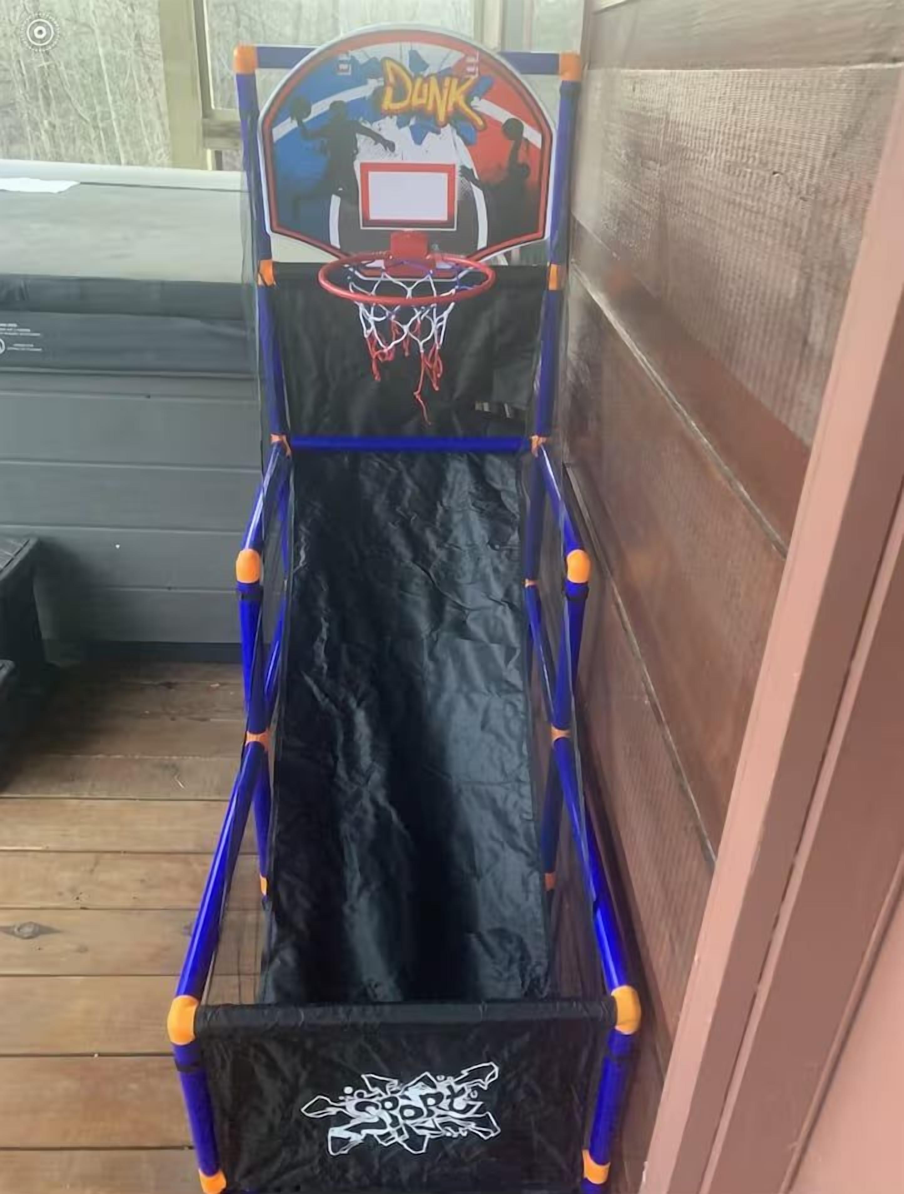 Ein mobiler Basketballkorb mit schwarzem Netz und dem Schriftzug 'DUNK'.