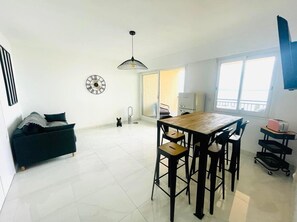 Relax in this stylish living space with a central dining table, comfortable sofa, and kitchenette.