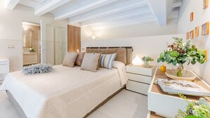 A bedroom with a bed, bedside table, and a wall-mounted plant. - Luxury 1 Bedroom Apartment with Elevator inside the Walls of Lucca by the Main Square Piazza San Michele (Lucca)