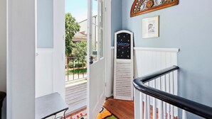 A staircase with a black railing, a welcome sign, and a decorative metal piece on the wall. - The House of Hue | 1870s Artful Savannah Retreat (Savannah)