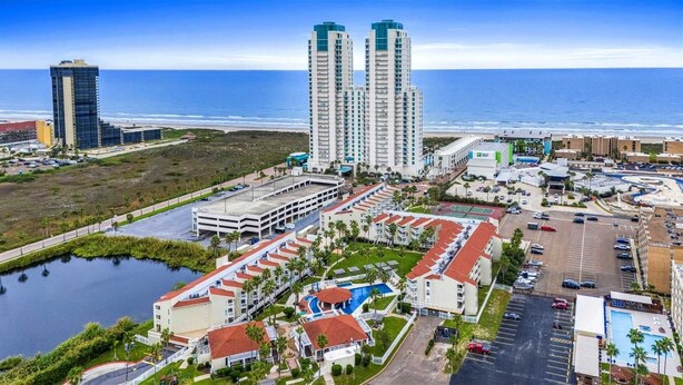 A coastal hotel complex with multiple high-rise buildings, a central parking area, and a swimming pool. - Gulfpoint 3209 2 Bedroom Condo by RedAwning (South Padre Island)