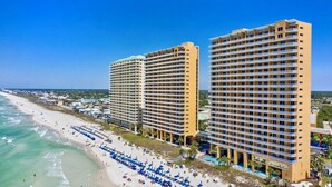 Een strandhotel met meerdere verdiepingen, een zwembad en voorzieningen direct aan het strand.