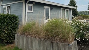 A single-story house with a grey exterior, white trim, and a small front porch. - Lovely Beach House for 4 persons within walking distance from the Beach  (Breskens)