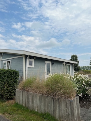 A single-story house with a grey exterior, white trim, and a small front porch.
