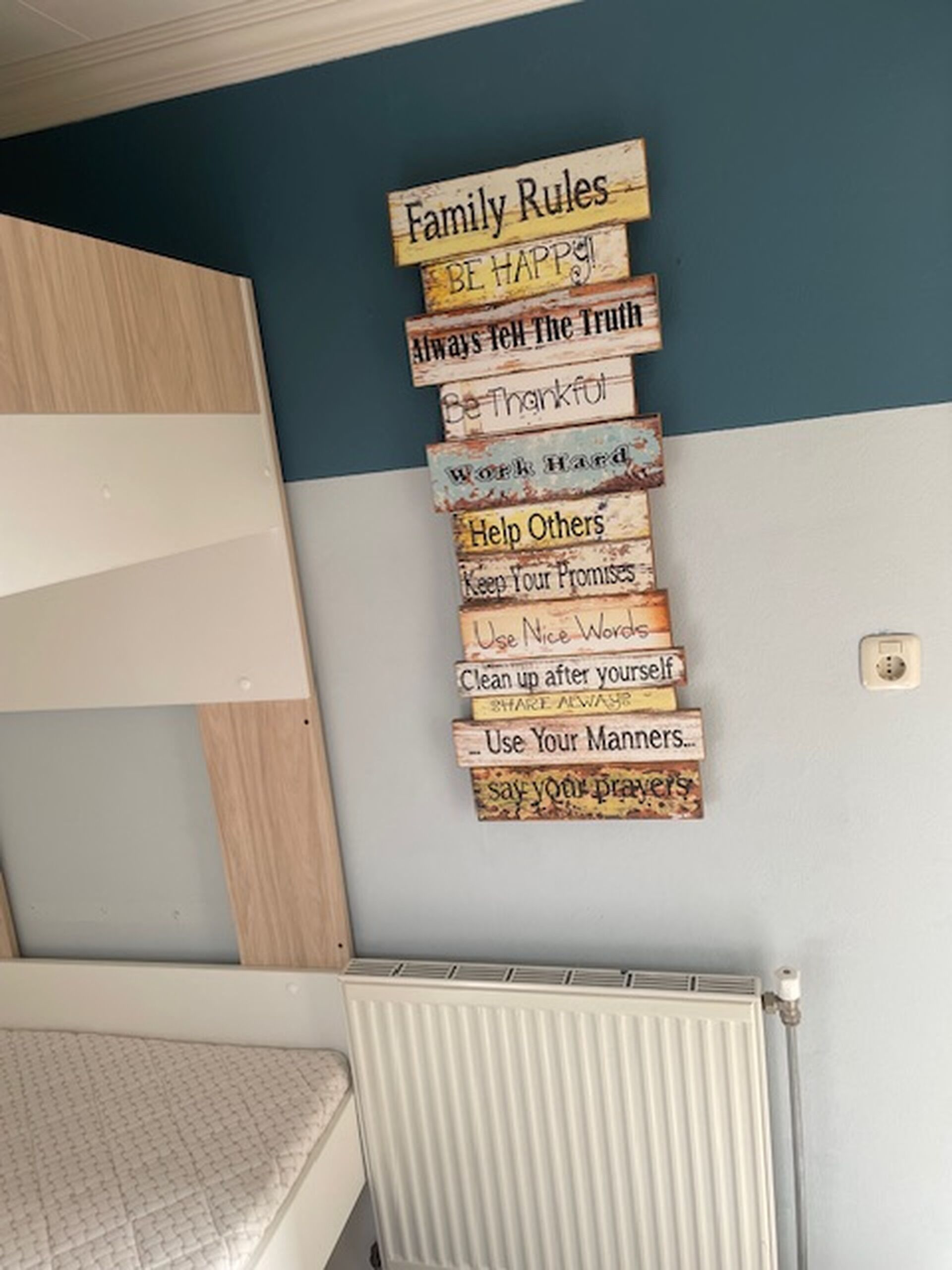 A wall with a series of wooden signs displaying family rules.