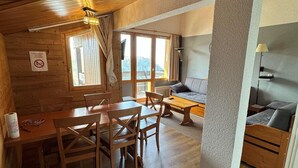 Una cabaña de madera acogedora con comedor, sofá y cama.