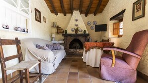 Una sala de estar acogedora con chimenea, muebles de madera y placas decorativas en las paredes.