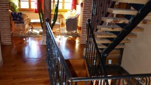 Una scala in legno con ringhiera in metallo che conduce a un piano superiore.