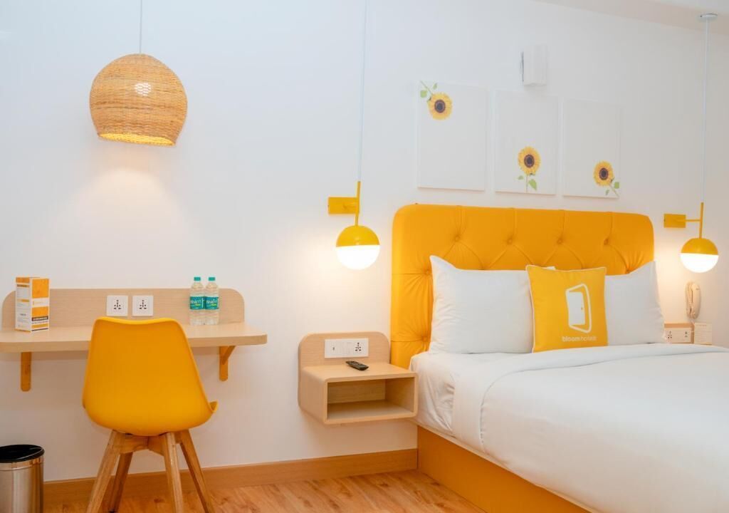 A hotel room with a bed, a desk, a chair, and a nightstand.