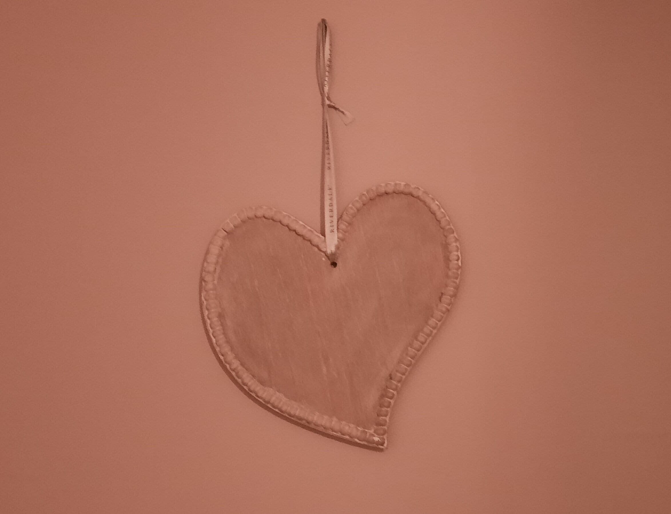 Una decoración con forma de corazón con un cordón colgando de la parte superior.