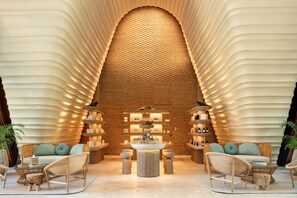 A modern lobby with a central seating area, a textured wall, and a variety of amenities.