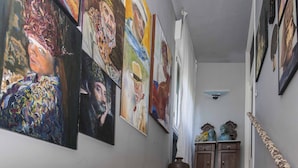 Una scala con ringhiera che conduce a un pianerottolo con un vaso e due statue.