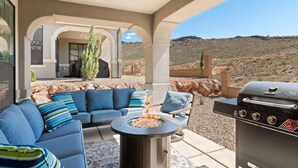 An outdoor patio with a fire pit, a barbecue grill, and blue cushioned seating. - The Gather Place, LOADED WITH GAMES, DESERT VIEWS (Washington)