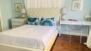 Ein ordentlich eingerichtetes Schlafzimmer mit Bett, Nachttischen, Schreibtisch und Stuhl.