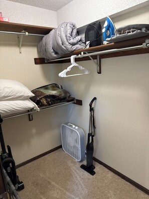 Una habitación pequeña con una cama litera, un aspirador y un calentador portátil.