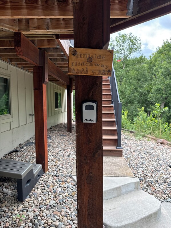 A wooden post with a 'Hillside Hideaway' sign and a Master Lock padlock.