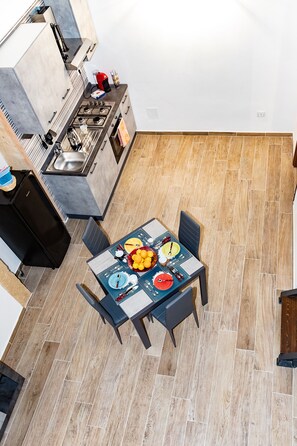 A modern kitchen with a gas stove, sink, and a dining area with a table set for four.