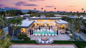 A modern hotel with a swimming pool, lounge chairs, and a well-maintained garden. - Private Pool + Spa + Bocce Ball Court + Fire Pit • Near La Quinta | Polo Villa 5 (La Quinta)