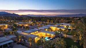 Ein Resort mit mehreren Gebäuden, Außenpools und Palmen.