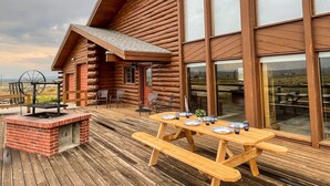 A wooden cabin with a deck, large windows, and a barbecue area. - Large cabin with amazing views, mountains, sunsets, and wildlife.
 (Pinedale)