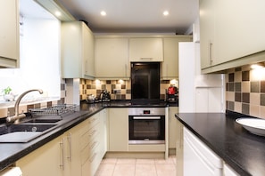 A compact kitchen with a sink, stove, oven, and a small countertop area.