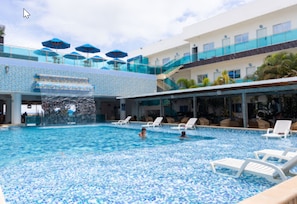 A swimming pool with multiple levels, lounge chairs, and umbrellas. - Hotel Poblado Coveñas (Coveñas)