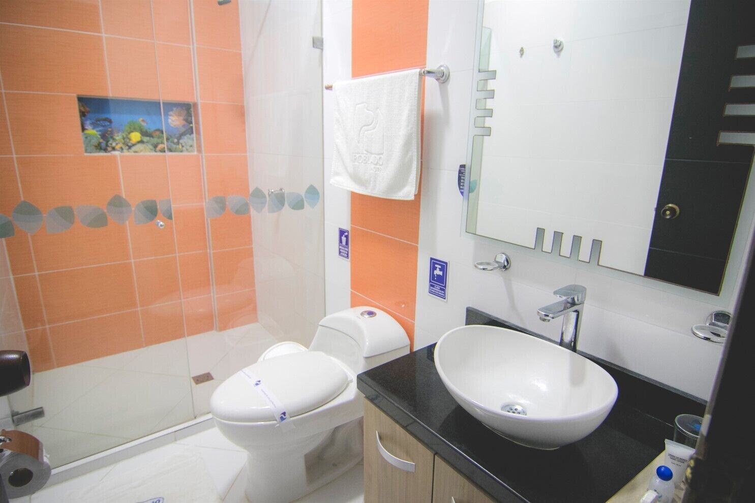 A bathroom with a toilet, sink, and shower.